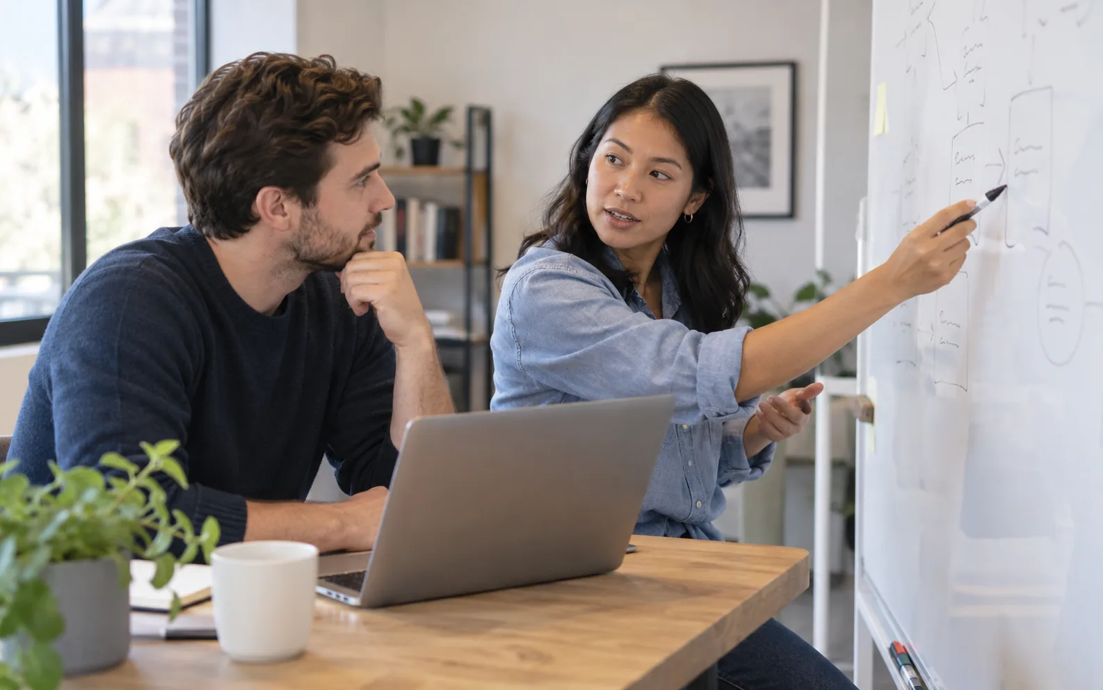 AI-created illustration of an engineer and an operations lead discussing a workflow at a whiteboard.